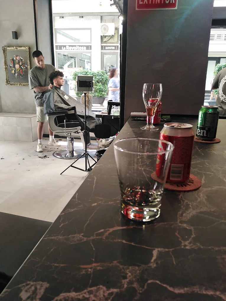 Barbero rematando un corte junto al escaparate